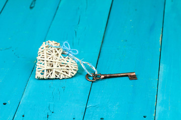 Wicker heart with skeleton key on teal blue background