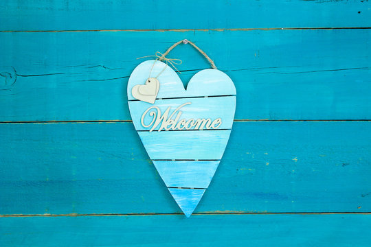 Welcome sign with heart hanging on blue background