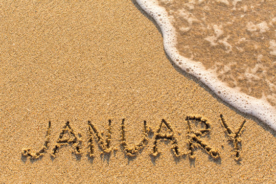 January - word drawn on the sand beach with the soft wave. Months series of 12 pictures.