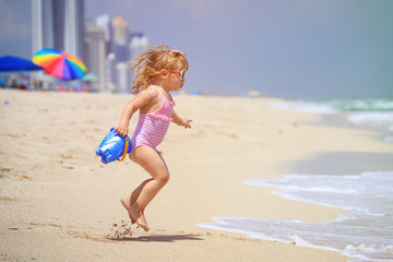 cute little girl play with water on beach