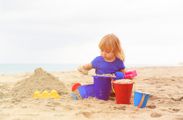 little girl play with sand on beach