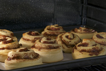 Hot Cinnamon rolls baking in a convection oven, almost done tops
