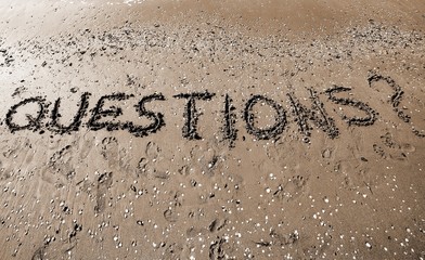 Word QUESTIONS written in large letters on the sand
