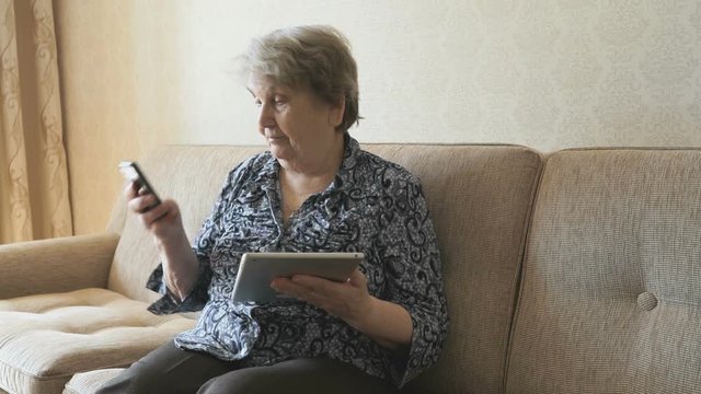 Elderly woman looks at pictures using a tablet
