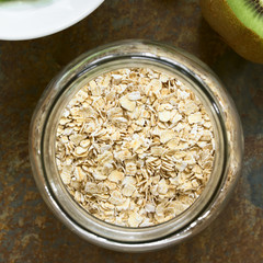 Oatmeal in jar, photographed overhead on slate with natural light (Selective Focus, Focus on the top of the oats)