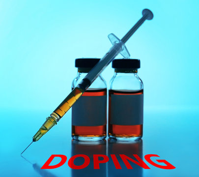 Stop doping concept. Medical ampule with syringe on blue background
