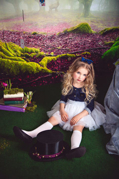 Pretty little girl as Alice in Wonderland and magician hat 