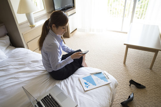 Business women have to check the smart phone in the room before going to work