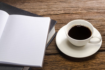 coffee with books and note book on old wood table
