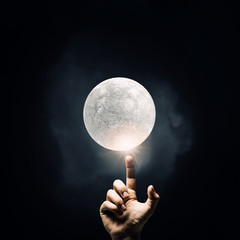 Finger reaching moon planet