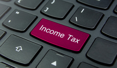 Business Concept: Close-up the Income Tax button on the keyboard and have Magenta color button isolate black keyboard