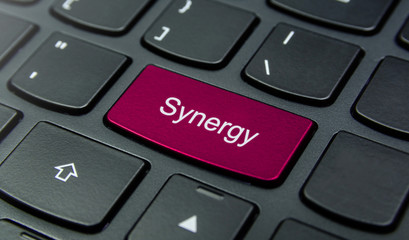 Business Concept: Close-up the Synergy button on the keyboard and have Magenta color button isolate black keyboard