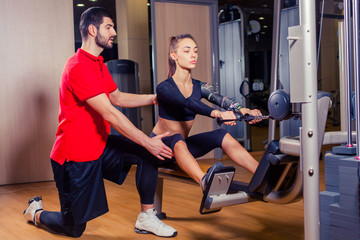 Personal trainer working with his client in gym