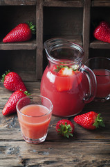 Sweet delicious strawberry juice on the wooden table