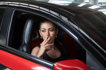 Fototapeta na wymiar woman smokes in the car
