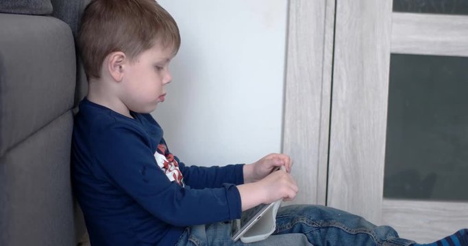 Boy Watching Cartoons on a Tablet Computer, Side View