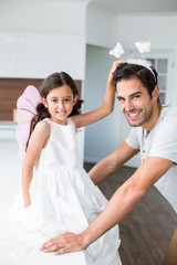 Obraz premium Portrait of smiling father with butterfly headband and daughter 