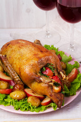 Roast duck with potato, apples, salad, thyme and rosemary. Two glasses of red wine