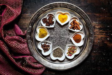 Round silver platter besides silk scarf on table