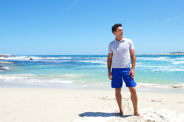 Fit middle aged man standing barefoot at the beach - Powered by Adobe