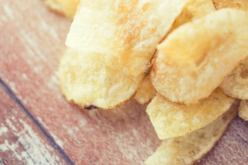 close up of crunchy potato crisps on wooden table