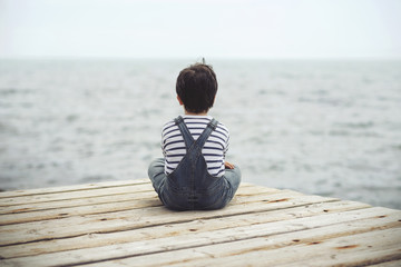 niño pensativo mirando el mar