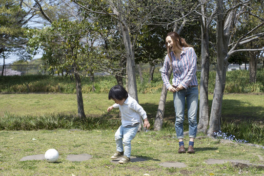 Mother and son playing with a ball in the park