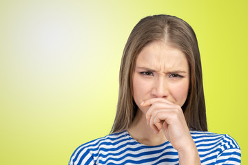 Portrait of a young woman holding her nose