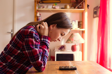 Young woman is waiting for a call or message and looking at her phone