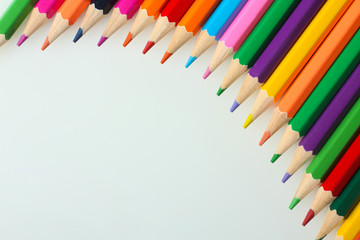 many colored pencils are in the shape of a wave near each other on a white isolated background