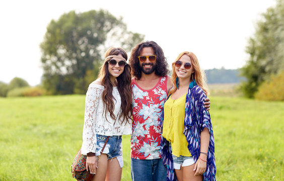 smiling young hippie friends on green field