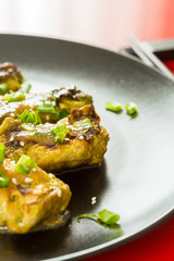 Chinese Stuffed Cabbage (Rolls) with Meat and Onion on the Black Plate on the Red Background, Close-up