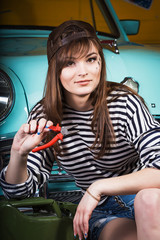 young attractive woman in a baseball cap sits in the garage near