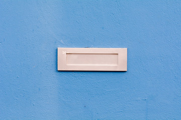 Letterbox in blue painted wall
