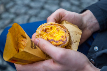 Portuguese Dessert Egg Tart (Pasteis de Nata) in Man's Hand, Close-up