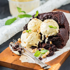 Healthy Vegan Chocolate Loaf (Cake) with Vanilla Ice-Cream Scoops, Walnut Pieces and Mint on Dark Grey Background