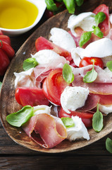 Italian salad caprese with ham, basil and mozzarella