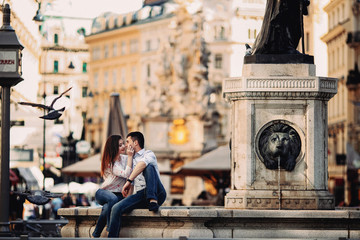 Couple in love sitting near fountain