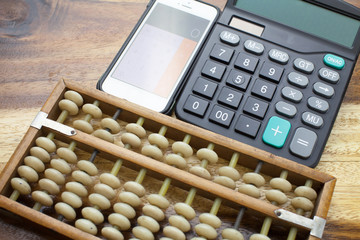 Smartphone,Abacus,calculator with wooden table background