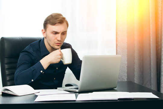Casual dressed man ready to drink coffee while checking news