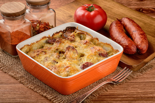 Casserole with potatoes, sausages, tomatoes and cheese.