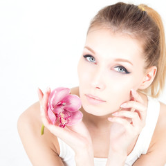 Portrait with permanent make up holding pink flower.