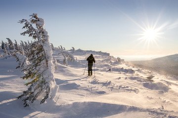 Fototapeta na wymiar Hiker Travel in winter mountains at sunrise in Ural