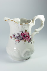milk jug with flowers on white background