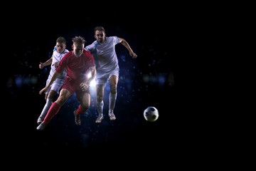 Soccer players in the air over black background