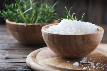 Sea salt and green rosemary on the wooden table