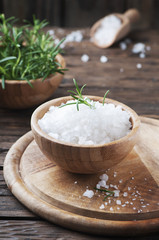 Sea salt and green rosemary in the wooden bowl