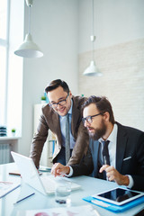 Two business men looking at laptop