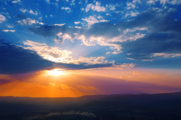 Raggi di sole al tramonto con il sole dietro le nuvole 