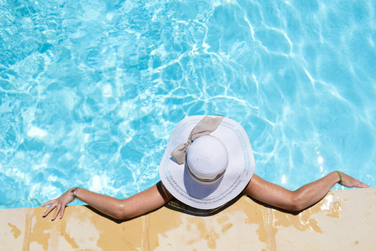 beautiful young woman in the swimming pool on a sunny summer day